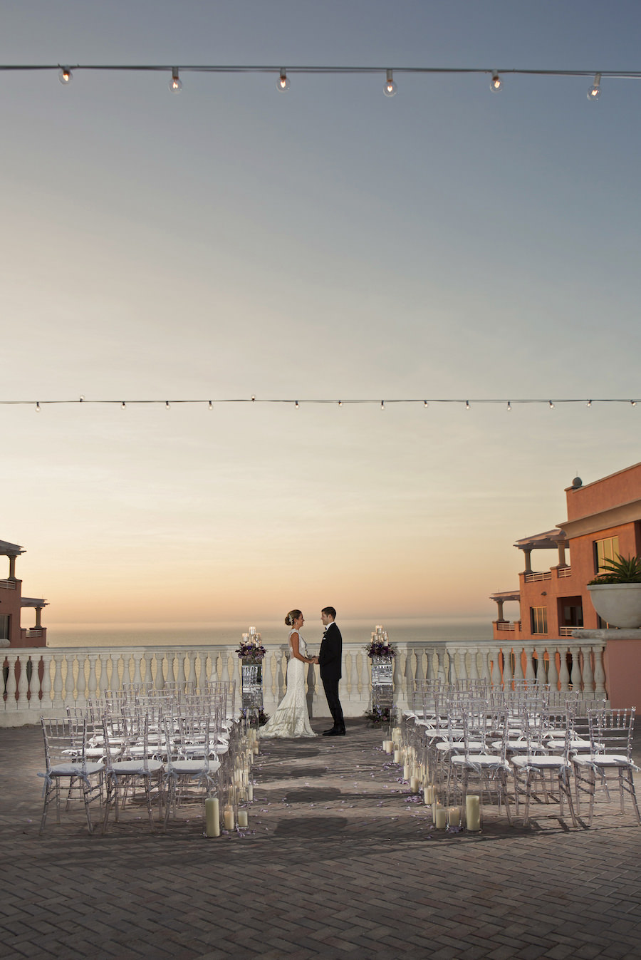 Sunset Candlelit Ceremony Aisle With Purple Rose Petals And Clear