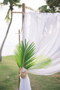 Bahamas Destination Beach Caribbean Lawn Grass Ceremony Venue with Bamboo Arch and Green Palm Leaves | Aisle Society Weddings Abaco Beach Resort