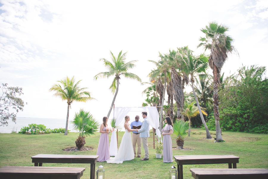 Bahamas Destination Beach Caribbean Lawn Grass Ceremony Venue with Bamboo Arch and Wooden Benches | Aisle Society Weddings Abaco Beach Resort