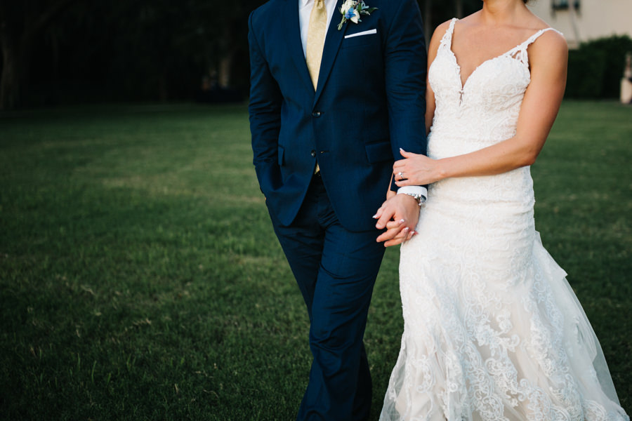 Outdoor, Bride and Groom Wedding Portrait Holding Hands in Ivory, Lace Martina Liana Dress and Blue Groom's Suit