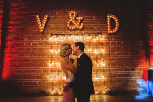 Bride and Groom Wedding Portrait with Lighted Marquee Monogram Letters, Exposed Brick and Industrial String Lights | Modern Industrial Wedding Reception Decor Inspiration | Downtown St. Petersburg Wedding Venue NOVA 535 | Special Moments Event Planning