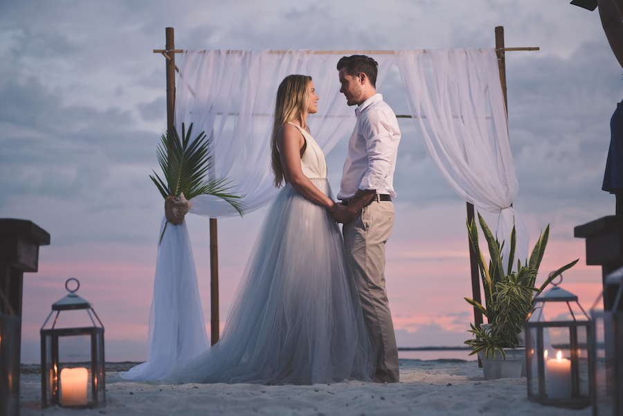 Bahamas Destination Beach Caribbean Sunset Ceremony Venue with Bamboo Arch, Silver Lanterns and Wooden Benches | Aisle Society Weddings Abaco Beach Resort