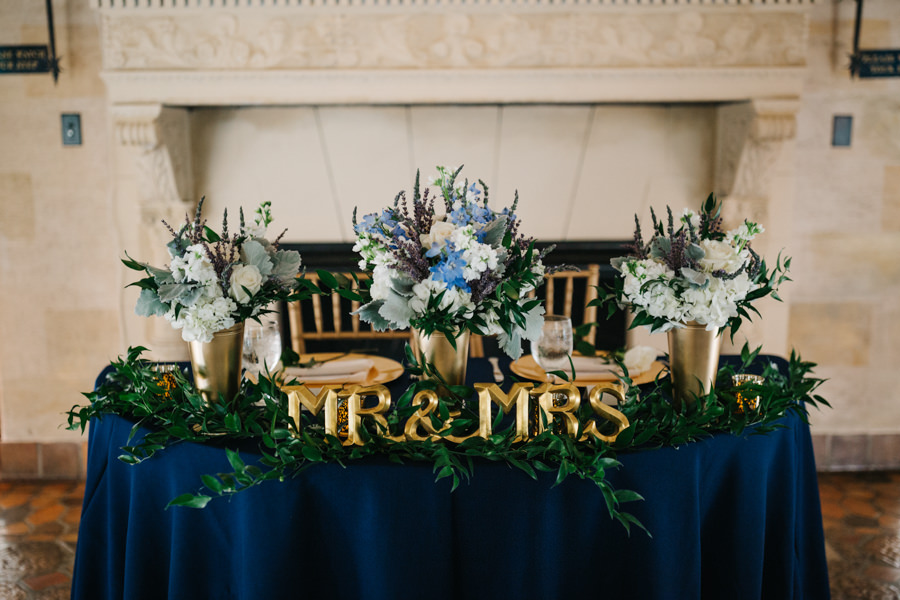 Wedding Reception Sweetheart Table with Blue and White Floral Centerpieces and Gold Mr and Mrs Letters and Navy Blue Specialty Linens | Sarasota Wedding Florist Apple Blossoms Floral Design | Wedding Planner Nicholle Leonard Designs