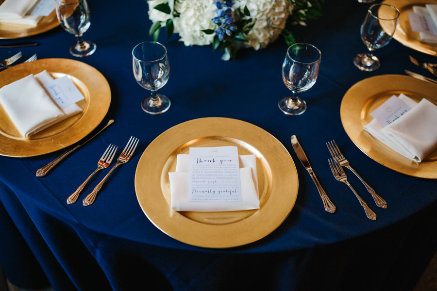 Elegant Wedding Reception Decor with Navy Blue Linens and Gold Chargers