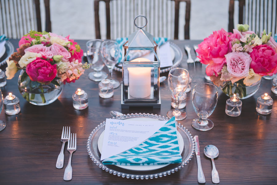 Bahamas Destination Beach Caribbean Reception Venue with Farm Tables, Bamboo Seating, Turquoise Green Napkins, Bright Pink Centerpieces and Glass Charger | Aisle Society Weddings Abaco Beach Resort