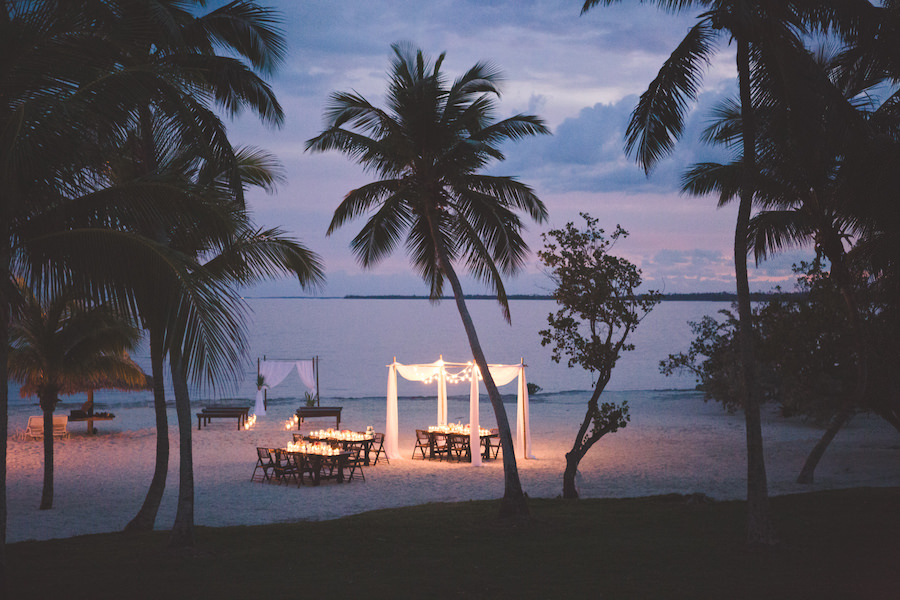 Bahamas Destination Beach Caribbean Reception Venue with Farm Tables, Bamboo Seating and Candlelight | Aisle Society Weddings Abaco Beach Resort