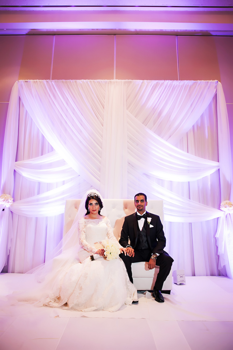 Elegant Indian Bride and Groom Ballroom Wedding Portrait with White Drapery Backdrop and Purple Uplighting | Downtown Tampa Hotel Wedding Venue Hilton Downtown | Wedding Photographer Limelight Photography