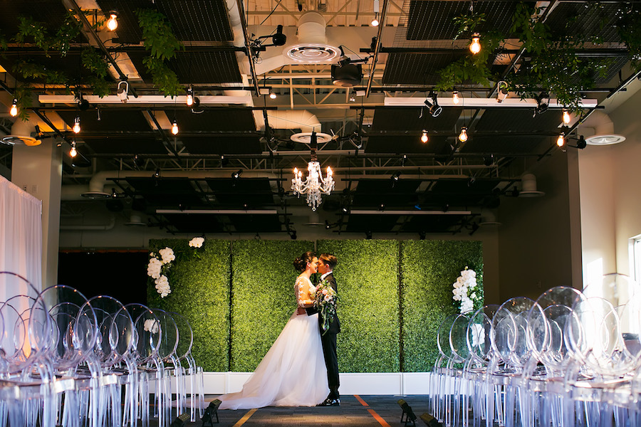 Modern Greenery Inspired Wedding Ceremony with Grass Wall, Chandelier and Ghost Chairs | Downtown Tampa Rooftop Wedding Venue The Glazer Children's Museum | Bridal Wedding Dress Shop Isabel O'Neil Bridal | Wedding Photographer Limelight Photography | Lighting Rental Nature Coast Entertainment Services | Furniture and Chair Rentals A Chair Affair