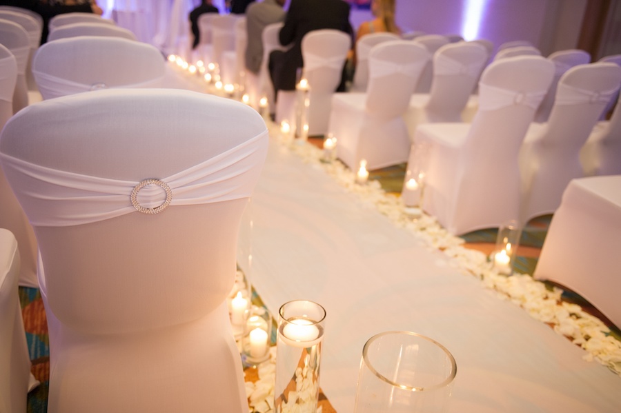 Elegant, Modern White Wedding Ceremony Seating with Candlelit Aisle and White Rose Petals