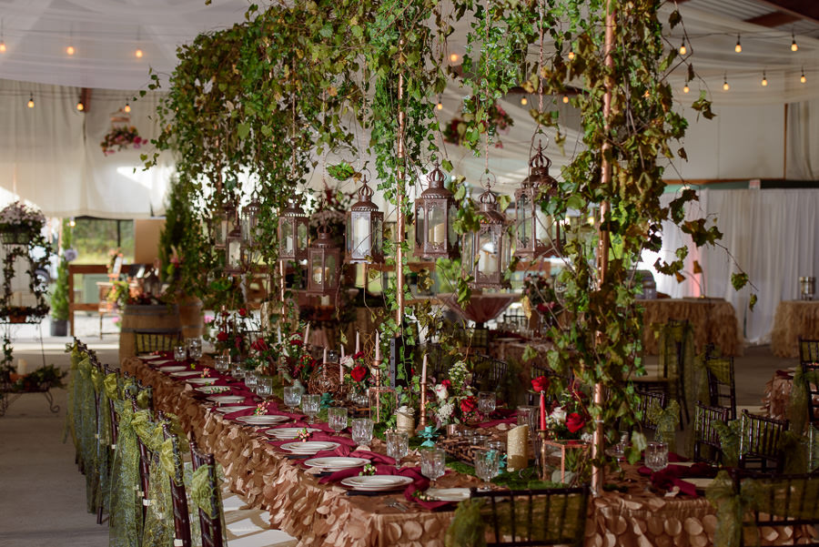 Spring Hill Wedding Reception Table Decor with Green Garland, Red Rose Centerpieces, and Brown Chiavari Chairs