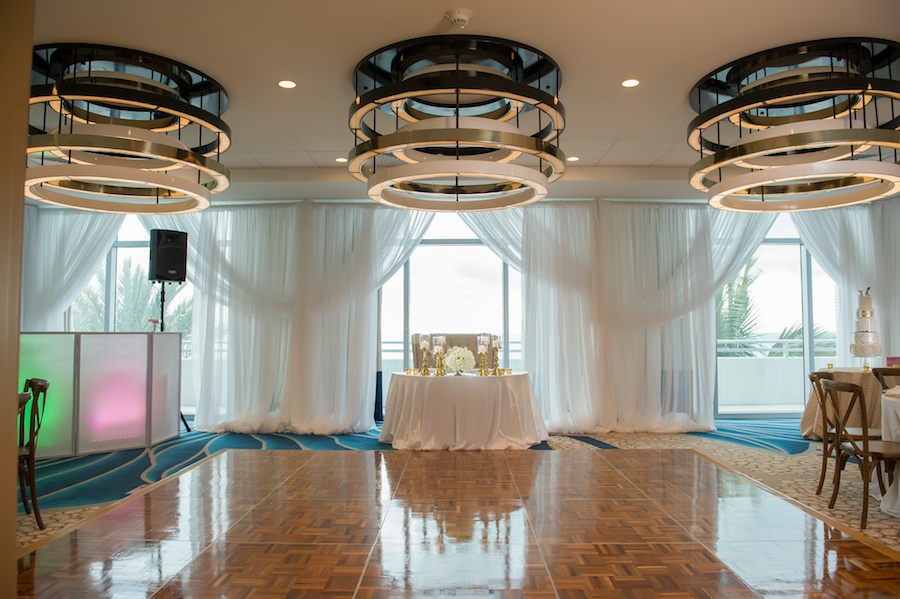 Modern White South Beach Inspired Wedding Reception Decor Sweetheart Table with Draping by Gabro Events Services and White Linens from Over the Top Linen Rentals | Clearwater Beach Wedding Venue Wyndham Grand | Wedding Planner Parties a la Carte