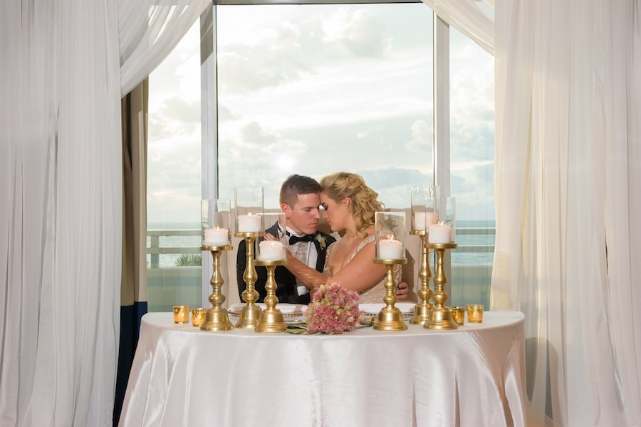 Modern White South Beach Inspired Wedding Reception Decor Sweetheart Table with Gold Candles, Draping by Gabro Events Services and White Linens from Over the Top Linen Rentals | Clearwater Beach Wedding Venue Wyndham Grand | Wedding Planner Parties a la Carte | Andi Diamond Photography