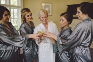 Bride and Bridesmaids Getting Ready Portriat in Grey Satin Robes Toasting with Mimosas