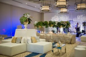 Modern White & Gold South Beach Inspired Wedding Reception Decor with Lounge White Furniture, Ghost Chairs and Tall Palm Leaf Centerpieces | Clearwater Beach Wedding Venue Wyndham Grand | Wedding Planner Parties a la Carte