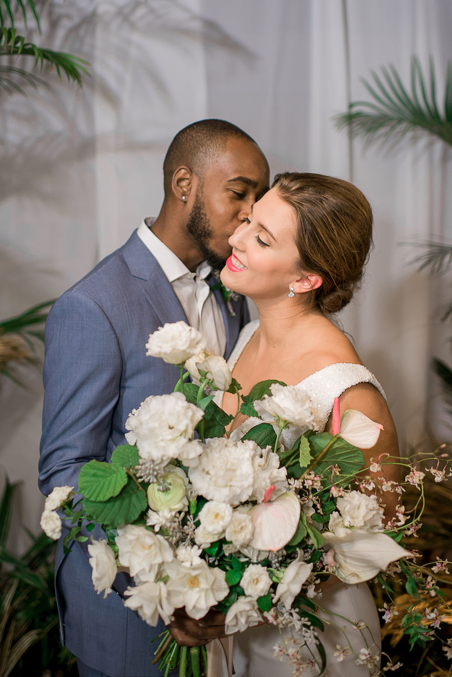 Bride in Beach Inspired Wedding Dress and Oversized Tropical Wedding Bouquet and Groom in Blue Grey Suit | Tropical Destination Beach Wedding Inspiration