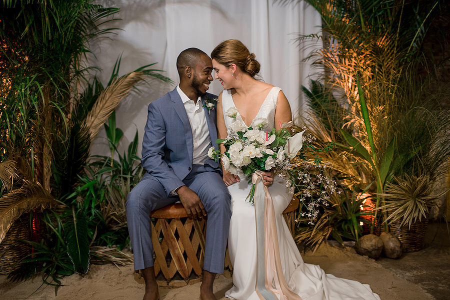 Bride in Beach Inspired Wedding Dress and Oversized Tropical Wedding Bouquet and Groom in Blue Grey Suit | Tropical Destination Beach Wedding Inspiration
