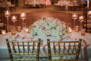 Sweetheart Table White Hydrangea and Blush Pink Rose Centerpiece Flowers with Tall Candles and Gold Chiavari Chairs | Wedding Reception Decor