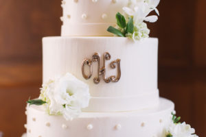 Bride and Groom Initials on Round, White Tampa Wedding Cake with White Floral Accents