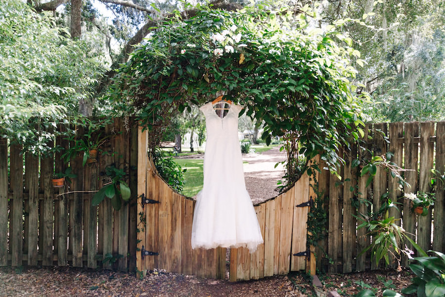 White, Beaded Lace Wedding Dress in Hanging in Rustic Woods