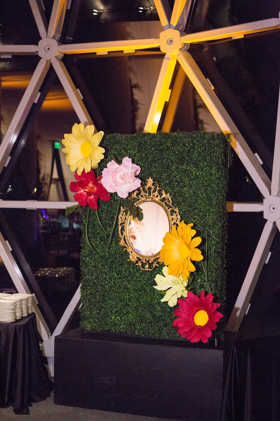 Alice in Wonderland Themed Whimsical Fairytale Wedding Reception Decor with Big Colorful Yellow and Red Paper Flowers with Green Grass Wall and Mirror | St. Petersburg Wedding Planner UNIQUE Weddings & Events