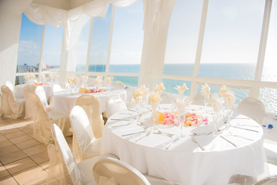 St. Pete Beach Indoor Waterfront Wedding Reception with White Linens and Gulf of Mexico Views with White Chair Covers and Satin Chair Ties