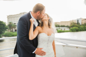 Outdoor Tampa Bridal Wedding Portrait with Bride in Sweetheart Lace and Beaded Wedding Dress with Veil, Kissing Groom Portrait | Bride and Groom Wedding Portrait aboard Yacht StarShip Wedding Venue