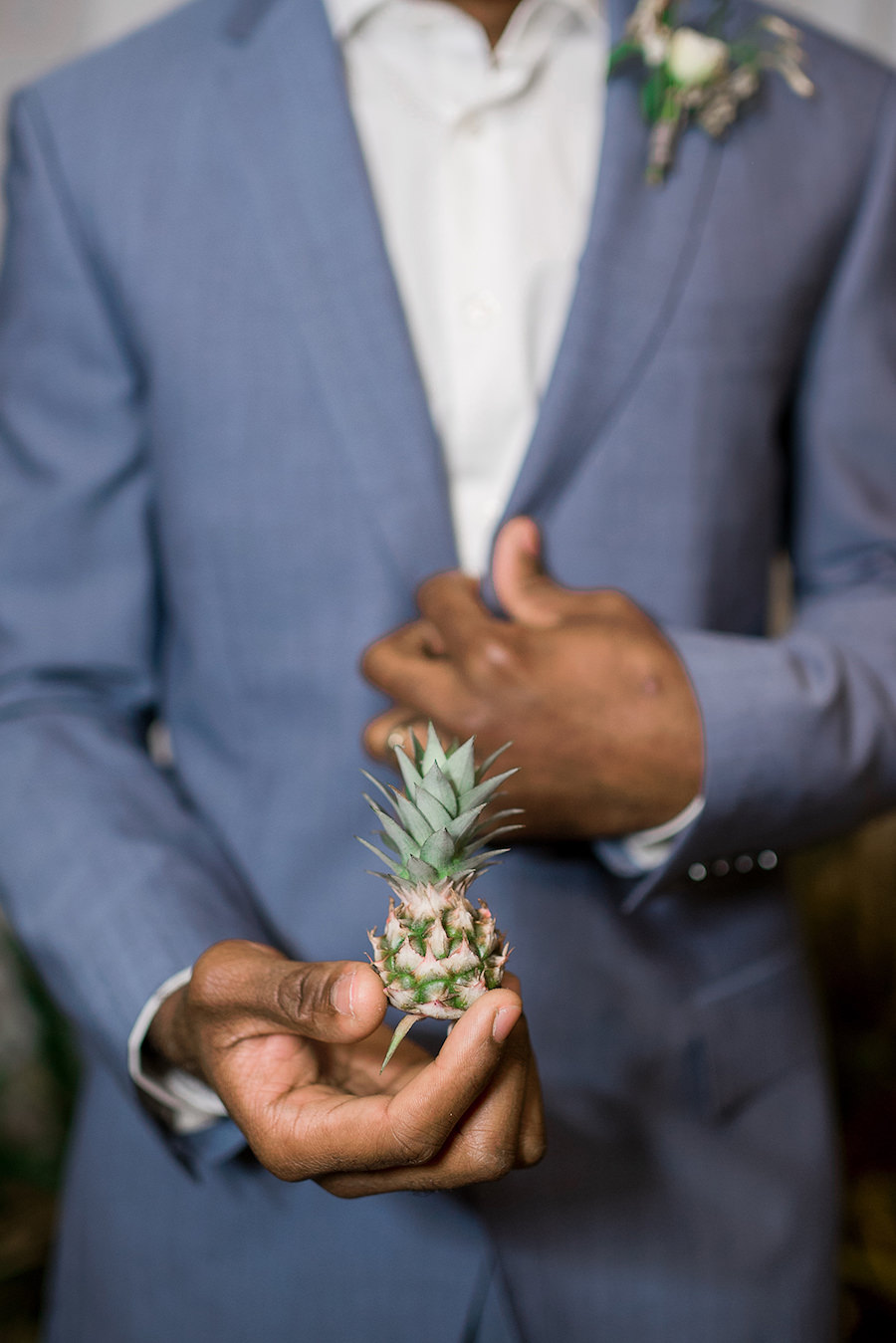 Groom in Blue Grey Suit holding Mini Pineapple | Tropical Destination Beach Wedding Inspiration