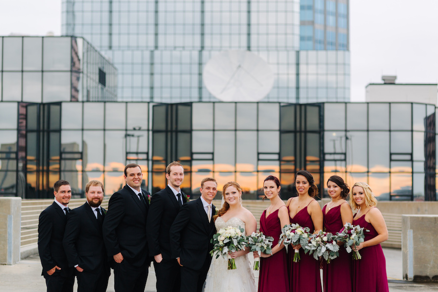 Outdoor Tampa Bridal Party Wedding Portrait | Burgundy Hayley Paige Bridesmaid Dresses and Black Groomsmen Suits | The Tampa Club Wedding Venue