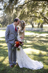 Bride with Soft Curl All Down Wedding Hair with Orange, Burgundy and Yellow Wedding Bouquet and Groom in Grey Suit | Bridal Wedding Portrait | Rustic Outdoor Wedding Venue The Lange Farm
