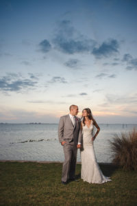 Bride and Groom Sarasota Waterfront Wedding Portrait in Grey Suit and Ivory Lace Sheath Allure Wedding Dress | Sarasota Wedding Photographer Marc Edwards Photographs | Private Mansion Wedding Venue Powel Crosley Estate
