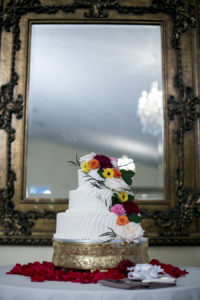 Three Tier White Round Wedding Cake with Bright Colors and Cascading Sunflowers on Vintage Filigree Brass Cake Topper