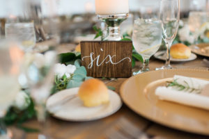 Rustic Wedding Reception with Wooden Table Numbers and Gold and Ivory Centerpieces | Inspire Weddings and Events Tampa Wedding Planning