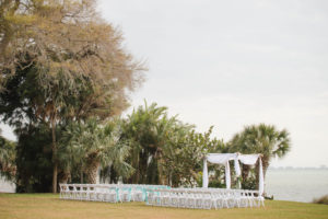 Beach Chic Outdoor Waterfront Wedding Ceremony with Wooden Wedding Arch Draped in White Chiffon | Sarasota Wedding Planning UNIQUE Weddings and Events | Photography by Marc Edwards Photographs