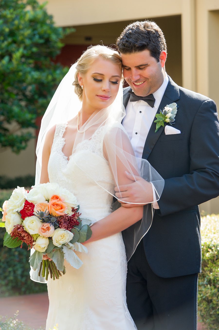 Bride and Groom Wedding Day Portrait in Lace Wedding Dress with Ivory, Red and Orange Floral Bouquet | Tampa Wedding Photographer Andi Diamond Photography