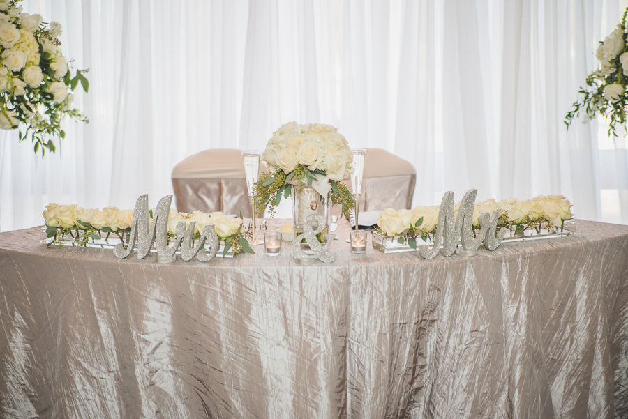 Silver Sweetheart Table with Silver Glitter Mr. and Mrs. Signs and Ivory Roses | Silver Wedding Reception Decor and Inspiration