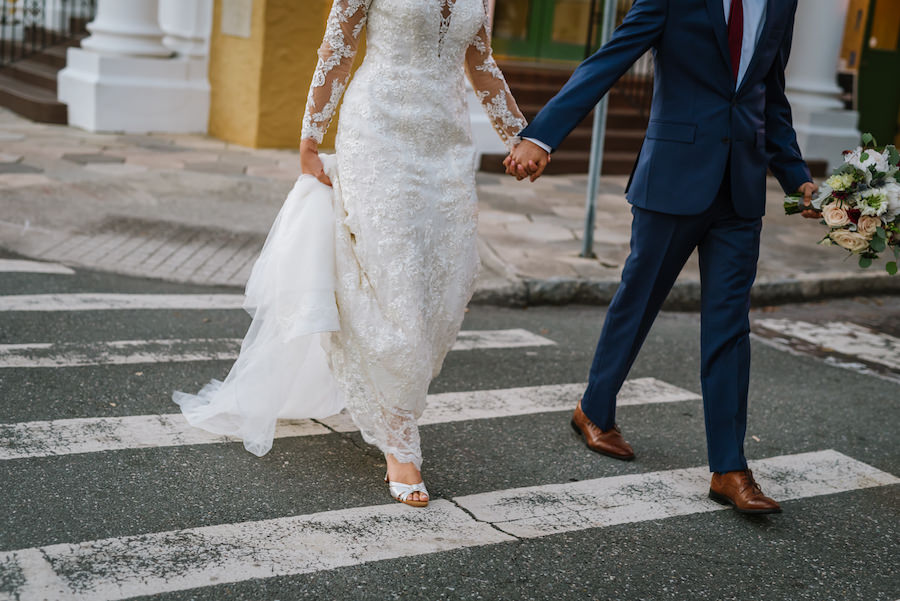 Downtown St. Pete Bride and Groom Wedding Portrait in Long Sleeve Lace Dress and Navy Blue Suit