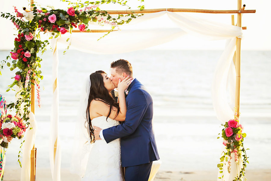 Tropical Beach Wedding Ceremony under Wooden Wedding Arch with White Tulle and Pink and Green Cascading Florals | Sarasota Wedding Photographer Limelight Photography