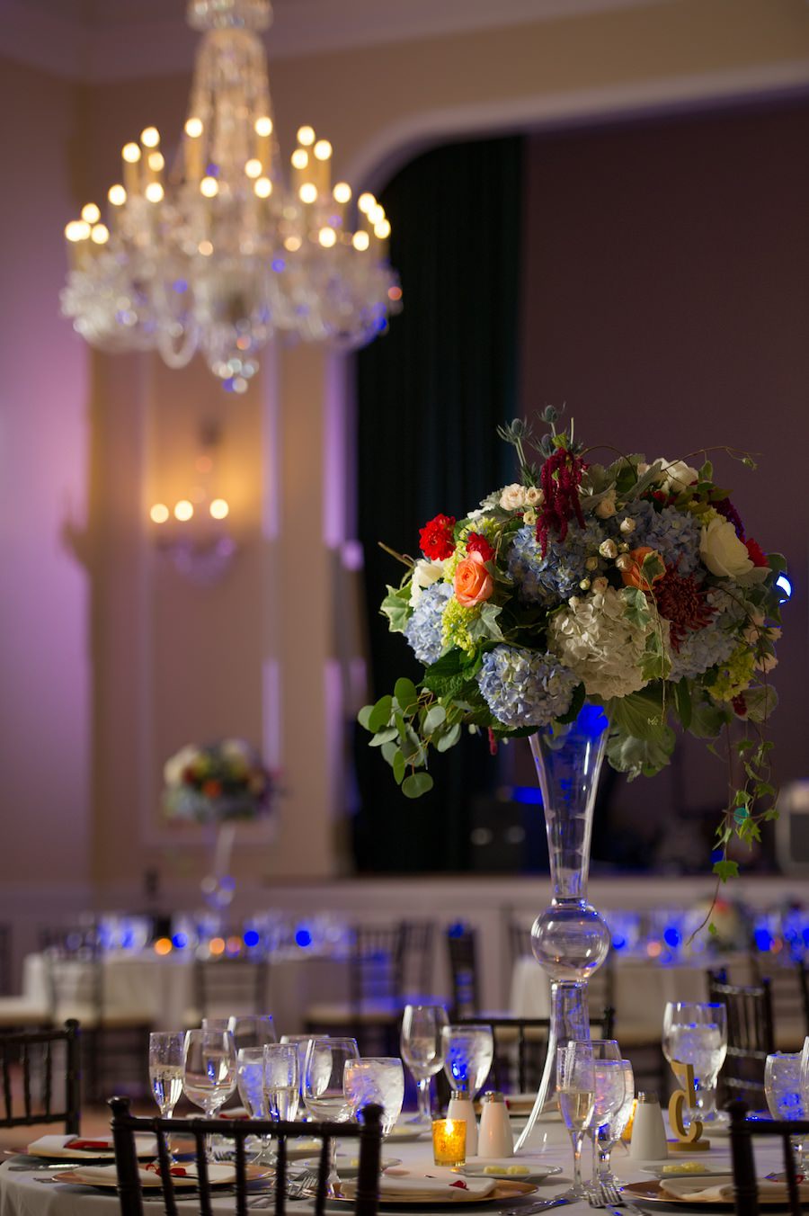 Classic Wedding Reception with Crystal Chandelier and Ivory, Blue and Cranberry Centerpieces in Tall Glass Vase | Tampa Wedding Photographer Andi Diamond Photography