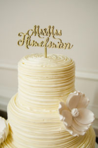 Three Tiered Round Yellow Wedding Cake with White Sugar Flowers with Gold Glitter Cake Topper