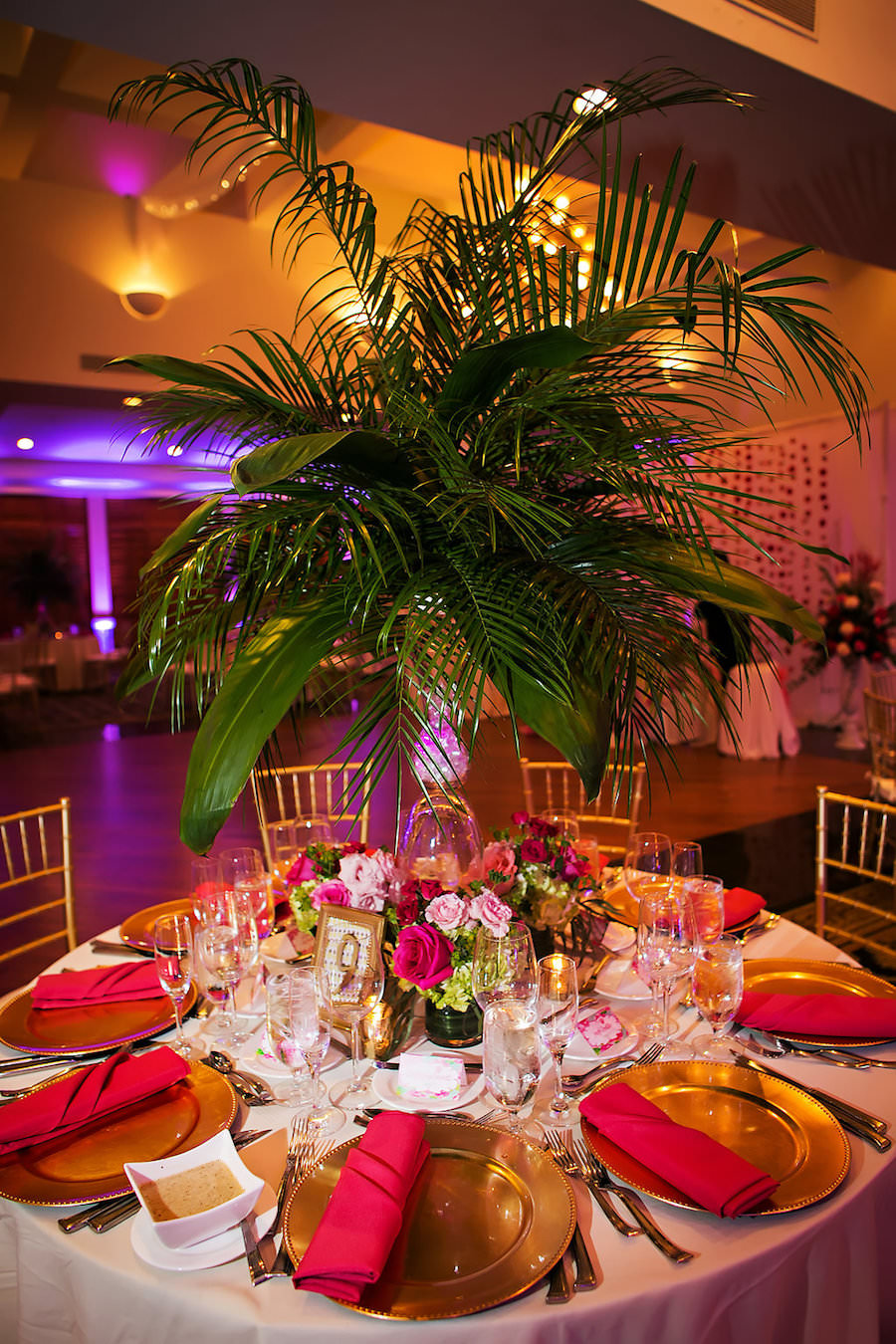 Tall Tropical Palm Leaf Wedding Centerpieces with Pink and Green Flowers | Gold Plate Charger with Pink Napkins and Gold Chiavari Chairs | Lilly Pulitzer Inspired Wedding Décor | Sarasota Wedding Photography by Limelight Photography