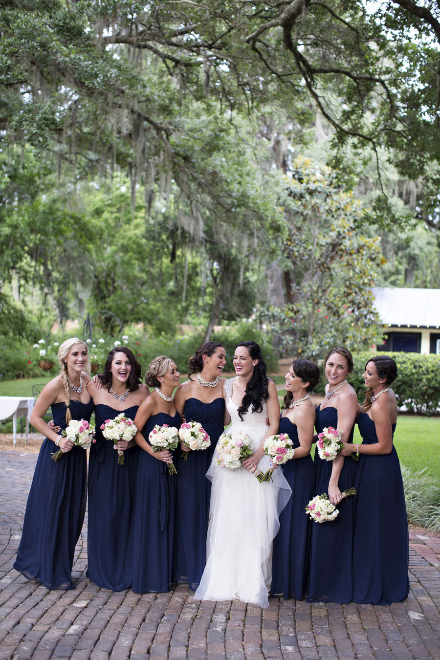 Outdoor Bridal Party Portrait with Ivory Ballgown and Navy Blue Bridesmaid Dresses with Ivory and Pink Bouquets | Tampa Bay Wedding Photographer Djamel Photography
