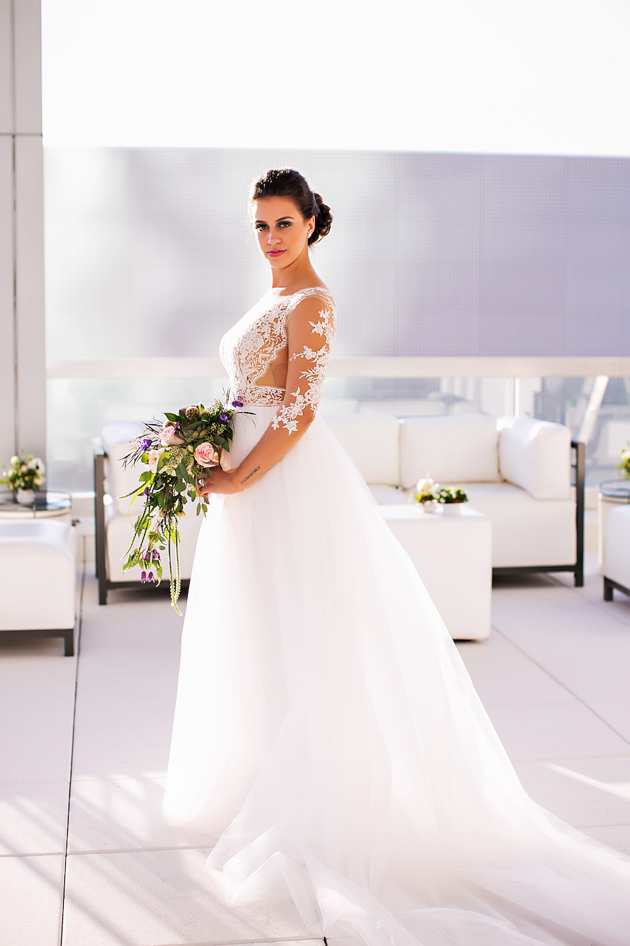 Rooftop Bridal Portrait in Nude Illusion Lace Wedding Dress with Sleeves with White Lounge Furniture | Tampa Bay Bridal Shop Isabel O'Neil Bridal | Wedding Photographer Limelight Photography | Downtown Tampa Venue Glazer's Children Museum | Rental and Decor Company A Chair Affair