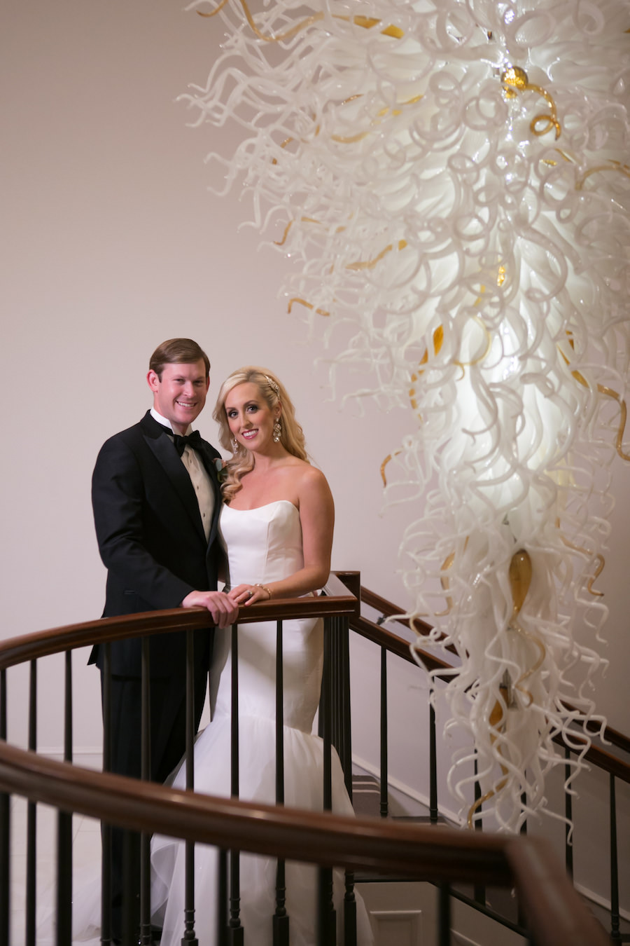 Bride and Groom Wedding Portrait at Top of Staircase with Modern Gold and White Chandelier | Wedding Venue The Tampa Club | Tampa Bay Wedding Photographer Carrie Wildes Photography