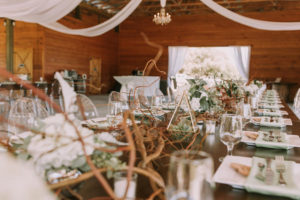 Outdoor Barn Wedding Reception Feasting Table with Rustic Wood Decor with White Hydrangea and Succulent Greenery Decor Centerpieces with Clear Ghost Chairs | Sarasota Wedding Planner Jennifer Matteo Event Planning