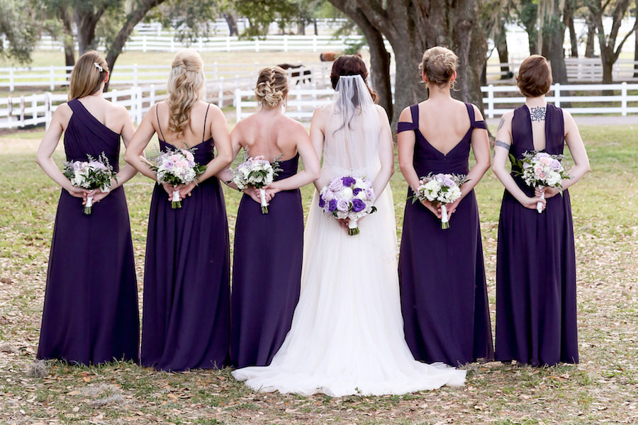 Outdoor Bridal and Bridal Party Wedding Portrait | Maggie Sottero Wedding Dress with Dark Purple Bill Levkoff Bridesmaids Dresses | Tampa Bay Wedding Venue The Lange Farm | Purple, Ivory and Lilac Roses Bridal Wedding Bouquet | Tampa Wedding Florist Northside Florist