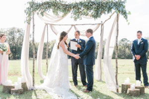 Draped Wedding Altar with Greenery Decor and Tree Stumps with Candles | Outdoor Wedding Ceremony at Tampa Bay Wedding Venue Orange Blossom Barn | Rustic, Country Wedding Inspiration