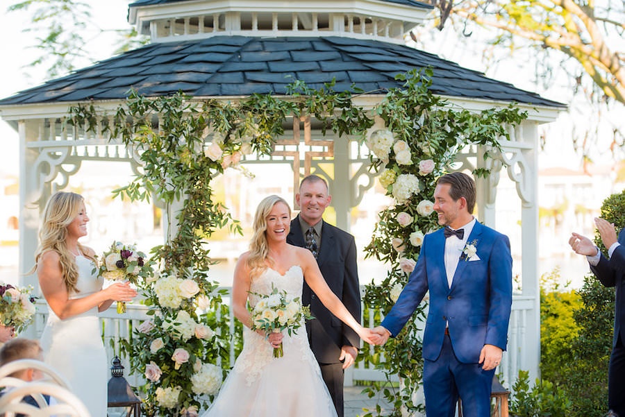 Outdoor Garden Wedding Ceremony under Wedding Arch of Greenery and Ivory Roses and Hydrangea Flowers | Tampa Wedding Photographer Kera Photography | Venue Davis Islands Garden Club