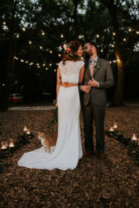 Bride and Groom Wedding Portrait with in Forest with Market String Lights and Orange Cat | Retro Vintage Boho Wedding Inspiration | Planner Glitz Events | Outdoor Venue Casa Lantana | Lighting by Gabro Event Services