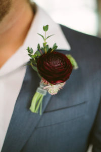 Modern Groom's Wine Colored Rose with Greenery Boutonnière on Grey Suit with White Button Down Shirt | Groom in Grey Suit Boutonnière Portrait