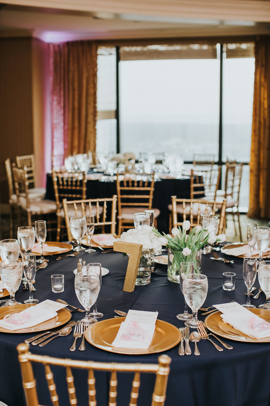 Elegant Gold Wedding Reception with Navy Blue Linens and Gold Chiavari Chairs with Gold Glitter Table Numbers | Wedding Reception Decor Inspiration and Ideas